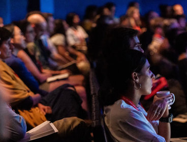 People sat in a theatre with laptops.