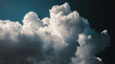 White fluffy clouds in a dark blue almost black sky. 