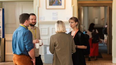 Four people networking at Annual Conference at the Royal Geographical Society.