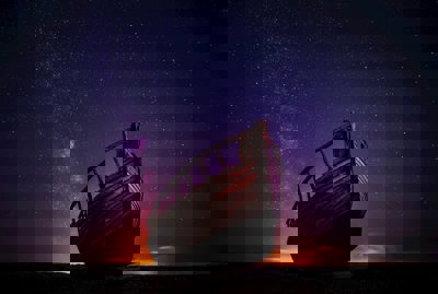 A brown ship against a nightime sky of stars