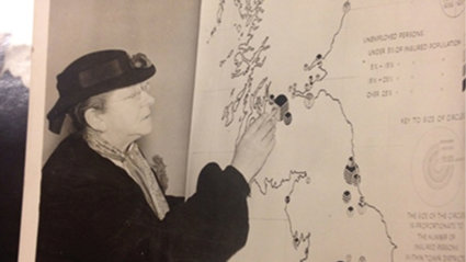 Old black and white photograph of Eva G.R. Taylor with a map on unemployment in England.