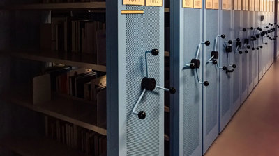 A row of blue metal archive shelves containing books.