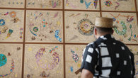 Hormazd Narwiella as seen from behind, standing in front of his mural at the Society and viewing it.