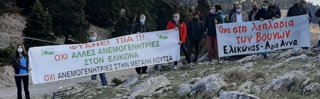 A group of people holding up two large banners in Greek.