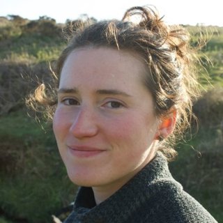 Person wearing jumper against green natural background.