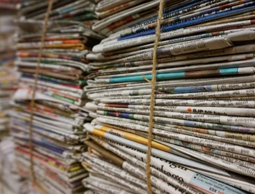 Piles of newspapers wrapped with string.