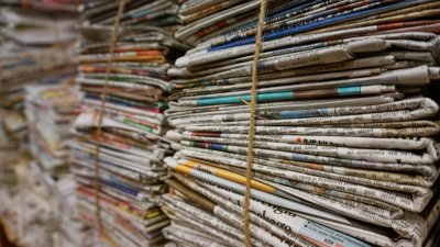 Piles of newspapers wrapped with string.