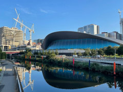 River flowing in urban area amongst modern buildings. 