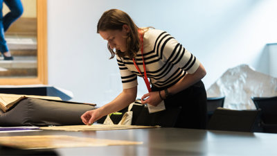 Beth Williamson inspecting some maps during the annual conference, in the Foyle Reading Room.