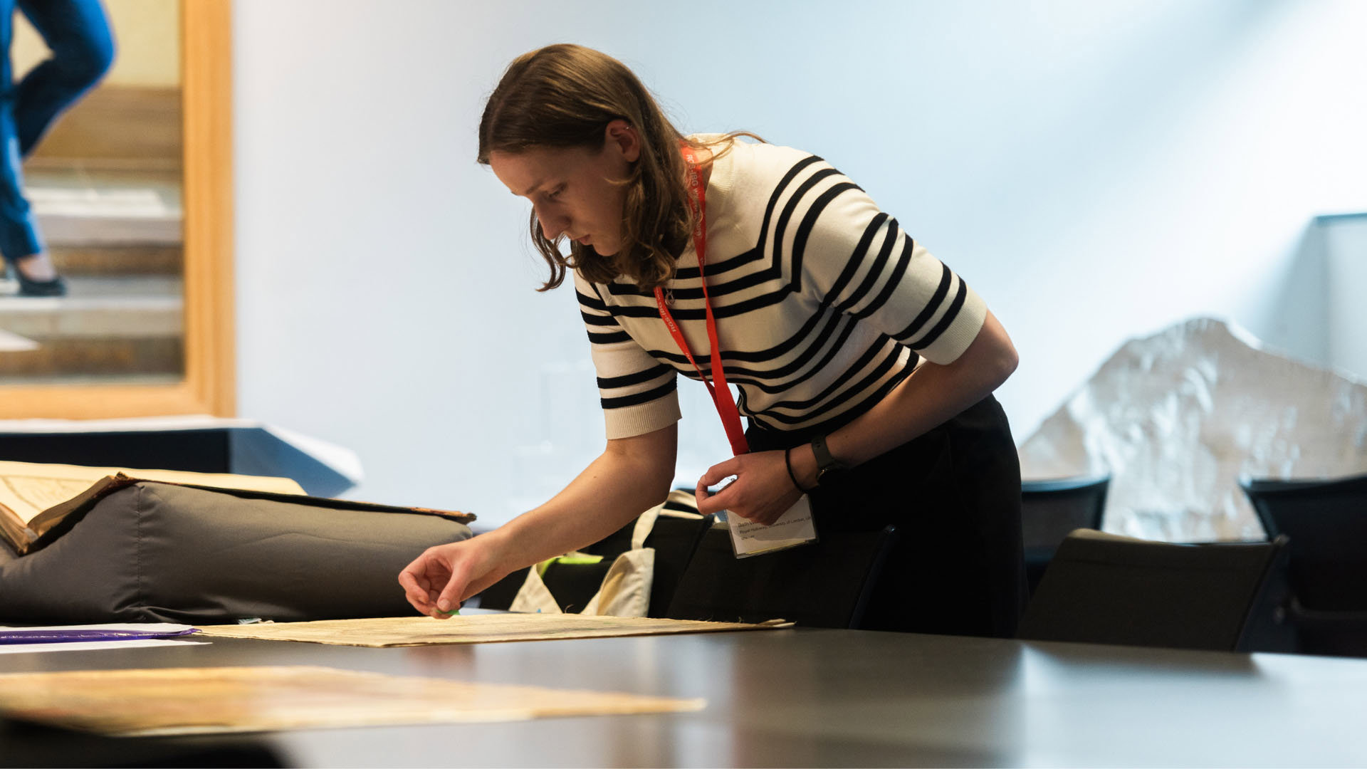 Beth Williamson inspecting some maps during the annual conference, in the Foyle Reading Room.