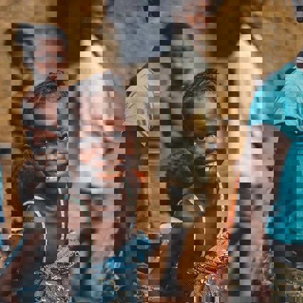 A group of Africa children looking to camera. One girl is focused on particularly and she is smiling