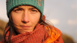 Headshot of person wearing red scarf.