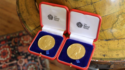 Two royal medals sitting on a floor globe.