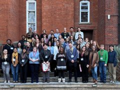 Group of Postgraduate students standing at the steps of the RGS terrace.