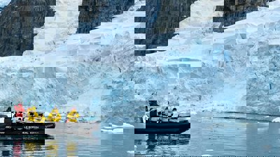 People in small boat near glacier