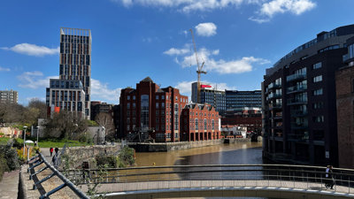 Bridge over a body of water, surounded by buildings.