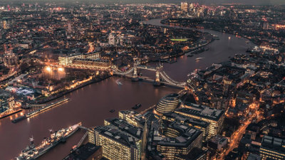 Aerial view of the City of London and Tower Bridge illuminated at night time.