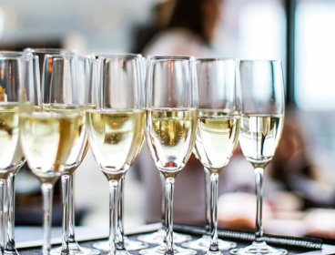Select focus of glasses of champagne and sparkling wine served on a tray.