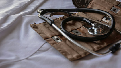 A stethoscope lays on its brown leather holder.