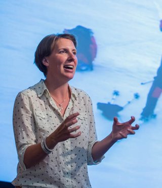 Felicity Aston on a stage giving a presentation.