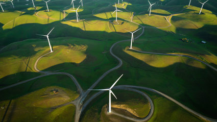 Wind farm located in green fields seen from above.