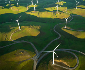 Wind farm located in green fields seen from above.