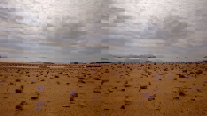 Brown sand under white clouds