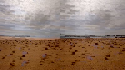 Brown sand under white clouds