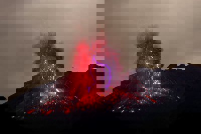 A volcano erupting, causing lightning to occur