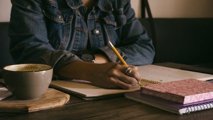 Person writing on paper notebook
