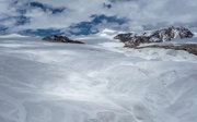A wide, barren, mountainous landscape covered in snow.