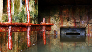 Inside sewage works with rusty pipes