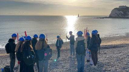 Teacher and students conducting geographical fieldwork on the beach.