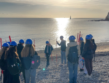 Teacher and students conducting geographical fieldwork on the beach.