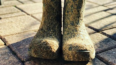 Two wellington boots covered in mud.