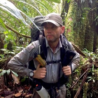 Pete Casey in a jungle with hiking gear.