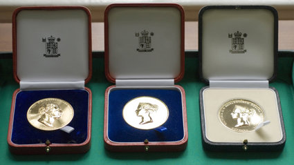 Three Society medals displayed in wooden boxes.