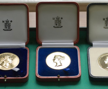 Three Society medals displayed in wooden boxes.