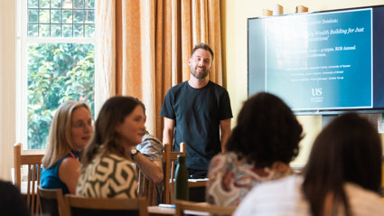 Person presenting to an audience in a casual environment.