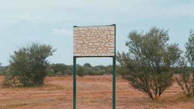 A map in the desert. Photograph titled 'A Thin Line Casts A Long Shadow'.