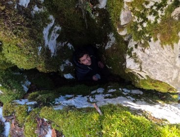 Person standing in between rock formation.