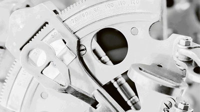 Close-up of a metal cog showing measurements in monochrome.