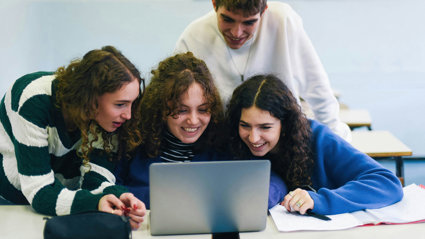 People looking at a laptop and smiling.