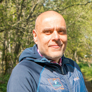 Headshot of Suresh Paul. He is outdoors on a sunny day.