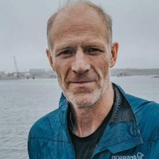 Børge Ousland head shot with water behind.
