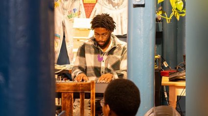 A person playing an instrument to an audience.