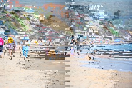 People on a beach walking and playing