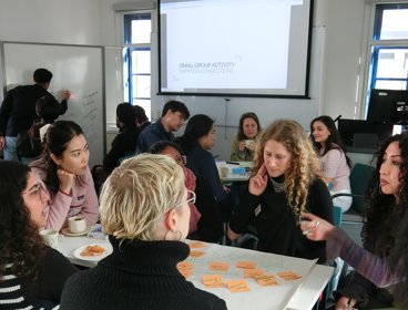 A group of people having a discussion around a table of post-it notes