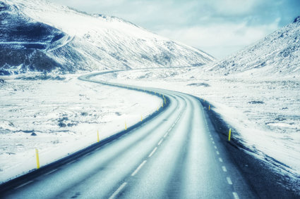 Winding road with snow covered mountains either side