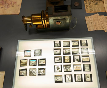 Display of historic materials, including photographs, lantern slides, and books.